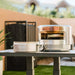 Solo stove pi pizza oven sitting on a stand in the backyard